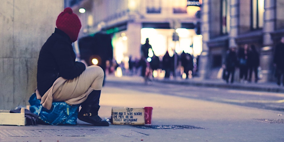 stock photo of male figure sitting on sidewalk looking at the city.