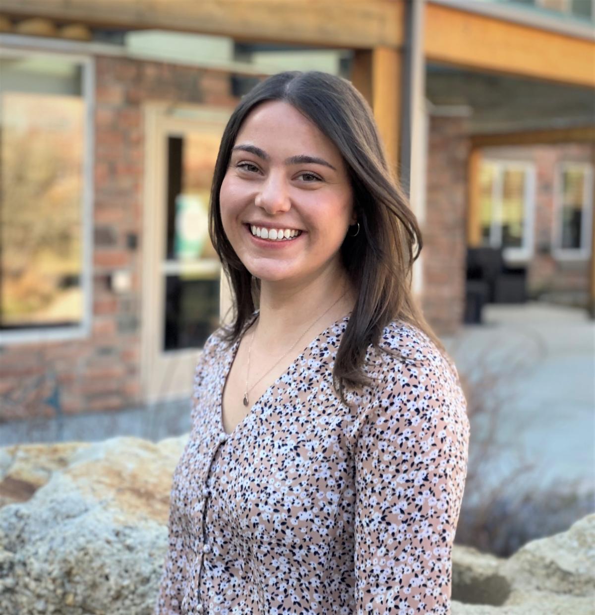 Headshot of Anna DeRocchi in a flower print dreass