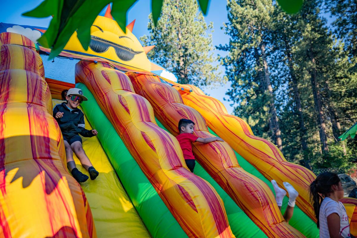 Children riding down an inflatable slide in the Kids Zone
