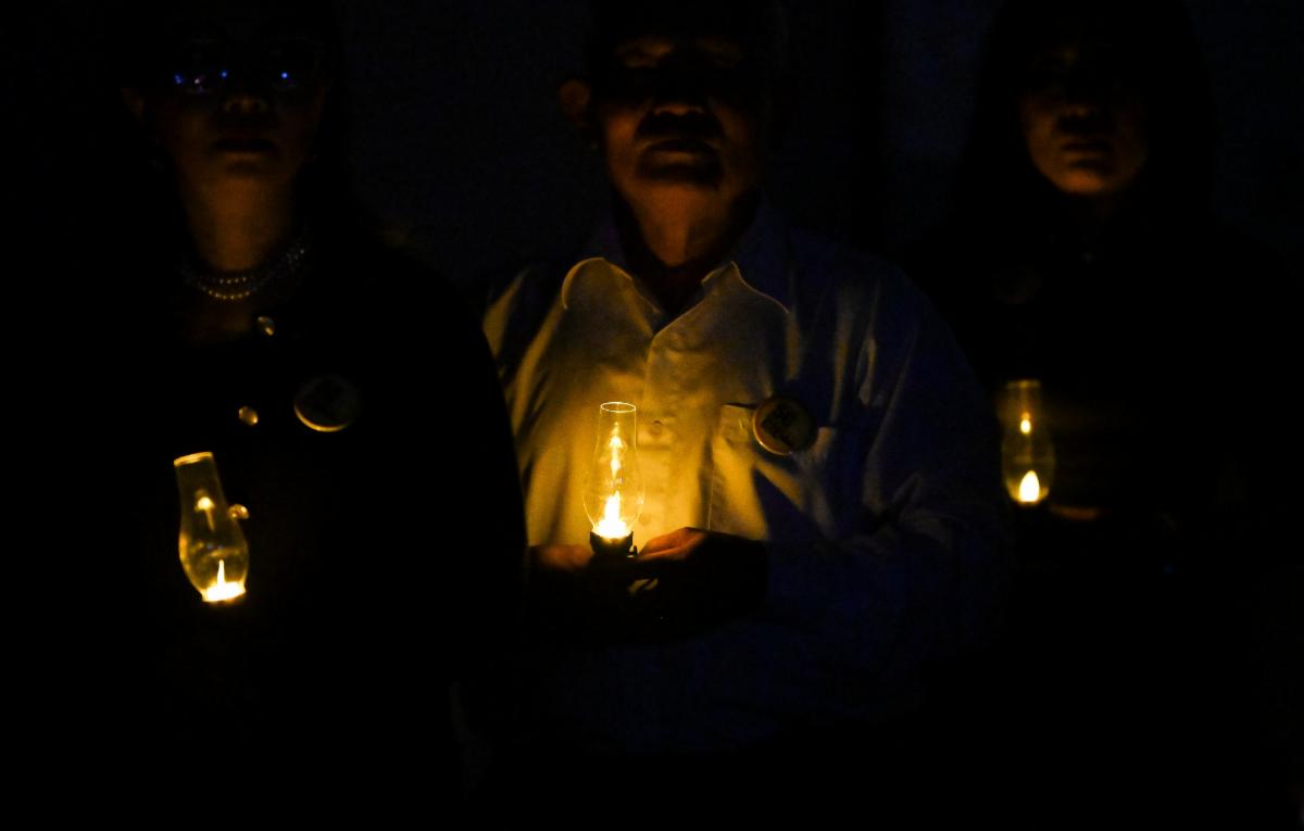 Members of the community hold lanterns in remembrance.