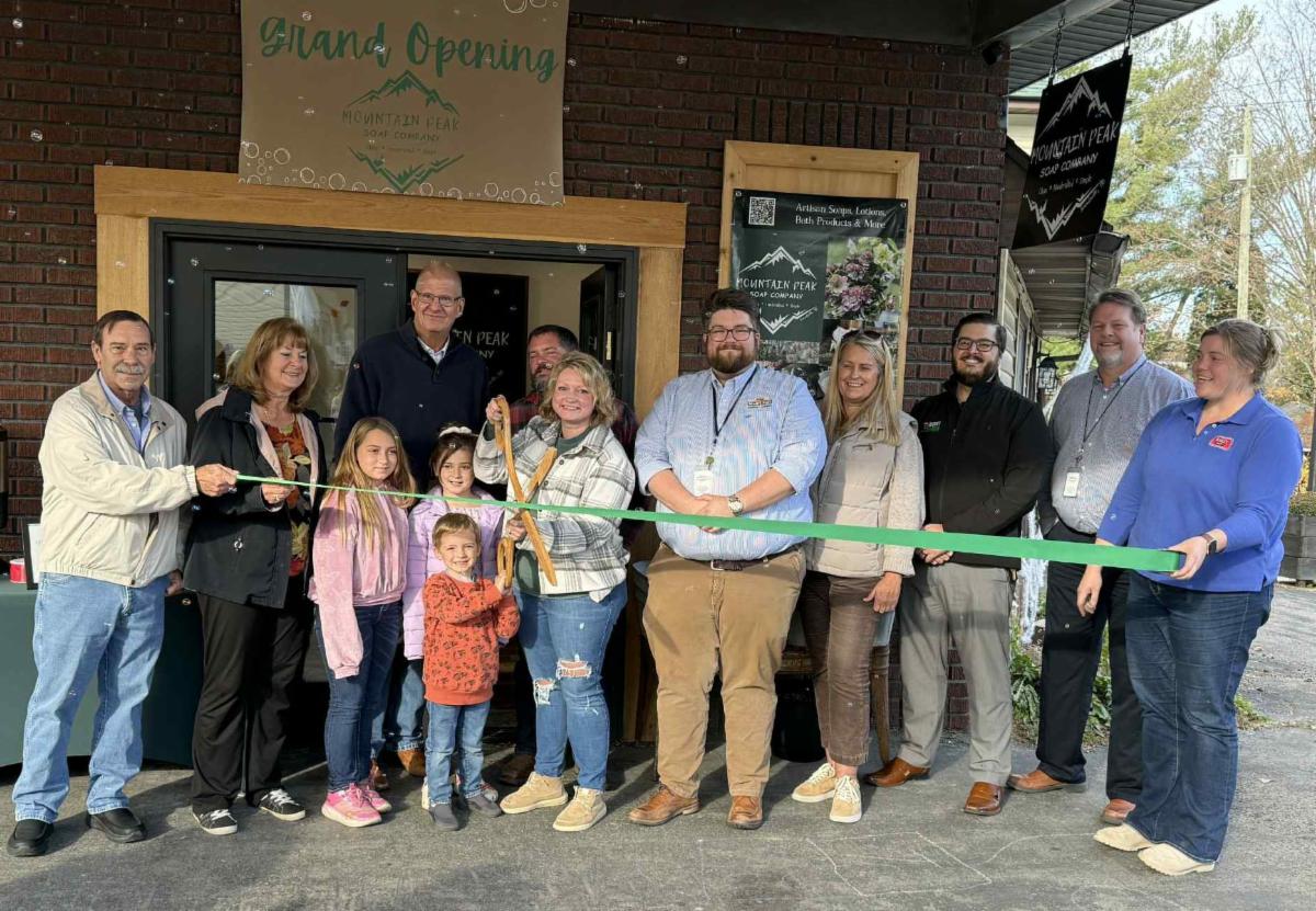 Men and women celebrating a ribbon cutting for Mountain Peak Soap Company in Friendsville