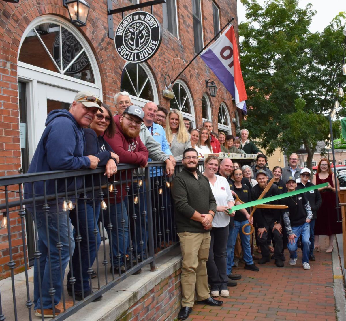 Men and women celebrating the ribbon cutting for Brewery and The Beast Social House in Downtown Oakland. Photo courtesy of Garrett County Chamber of Commerce.