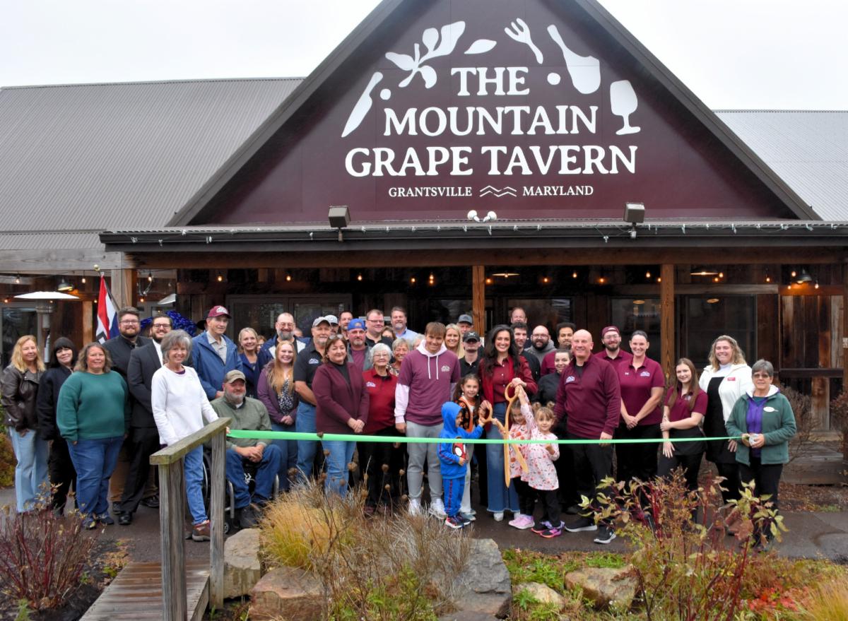 Men and women celebrating a ribbon cutting for The Mountain Grape Tavern in Grantsville.