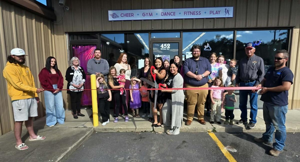 Men, women and children at the ribbon cutting for Cosmic Cheer's new location in Oakland.