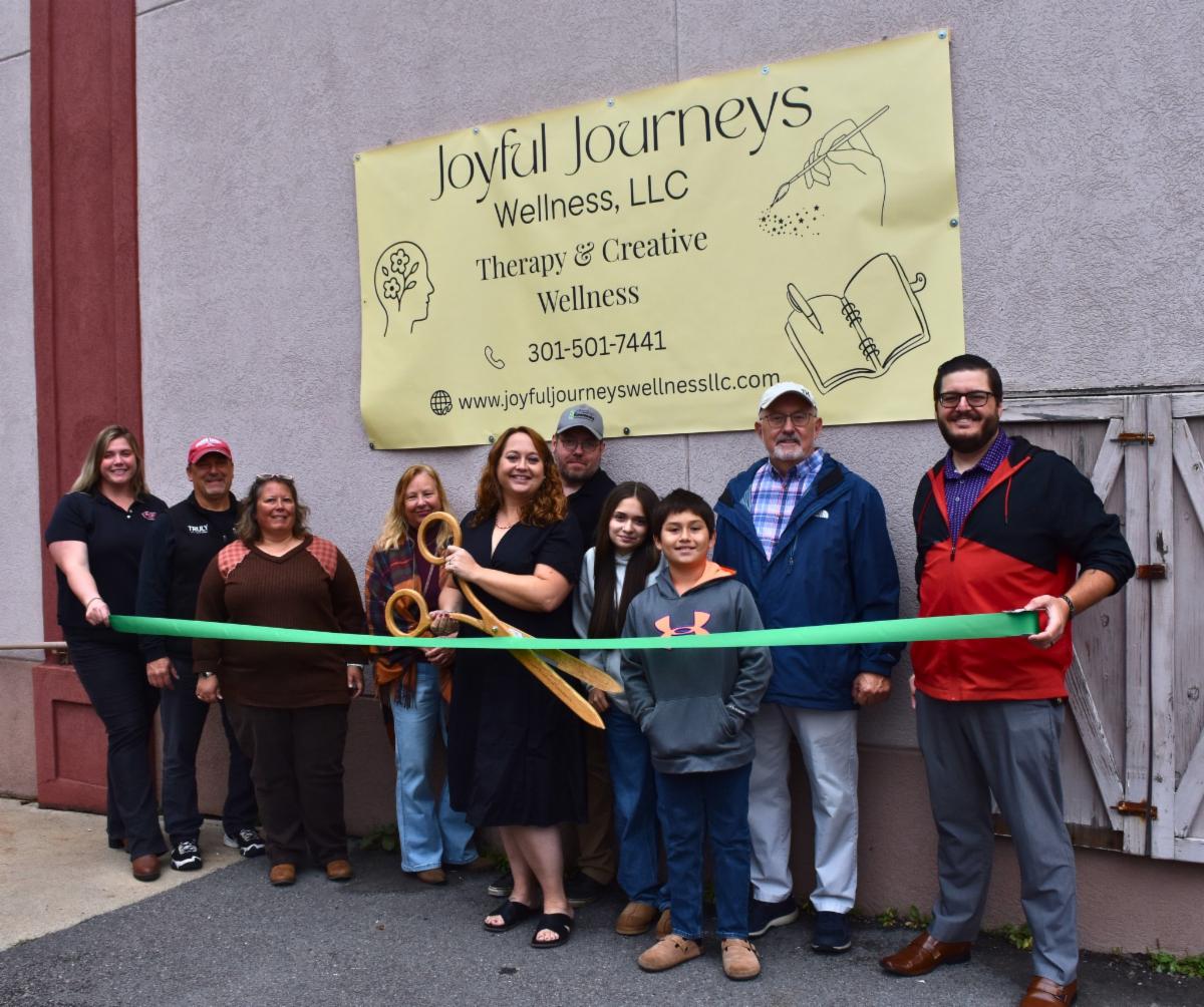 Men and women celebrating a ribbon cutting for Joyful Journeys Wellness.