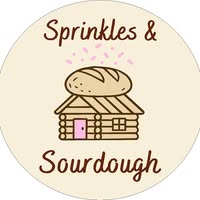 Logo: Sprinkles & Sourdough. Brown lettering on a cream background, with a house and loaf of bread in the middle of the logo.
