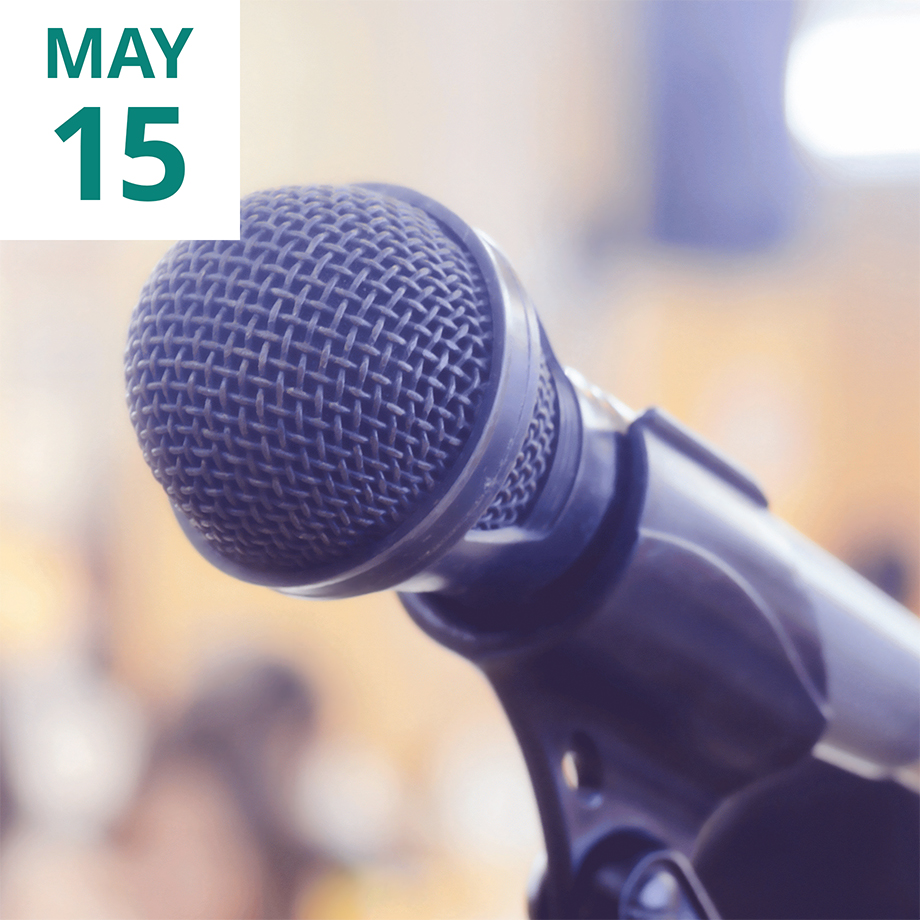 Image of a microphone with a blurry audience in the background
