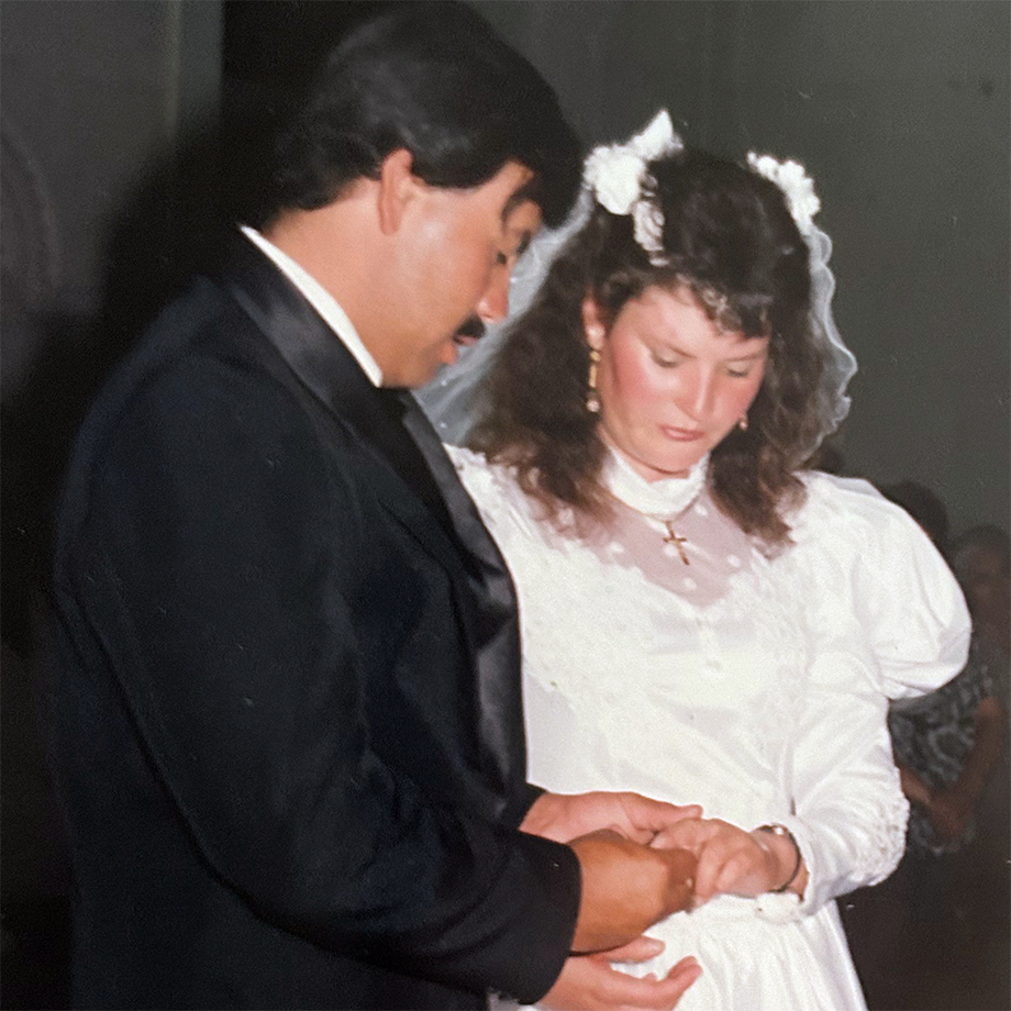 A photograph of a wedding between a man in a black tuxedo and a woman in a white wedding dress