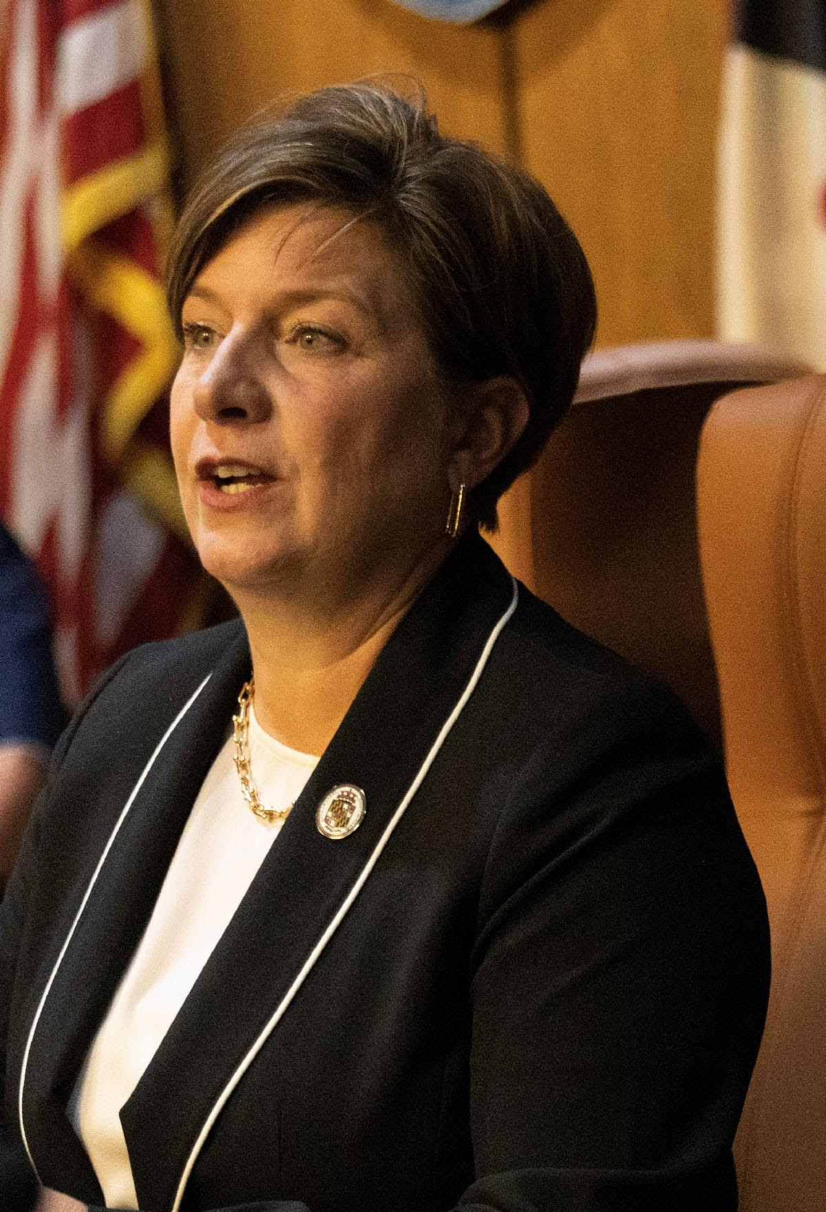 Pickard seated at Council dias with American flag in background