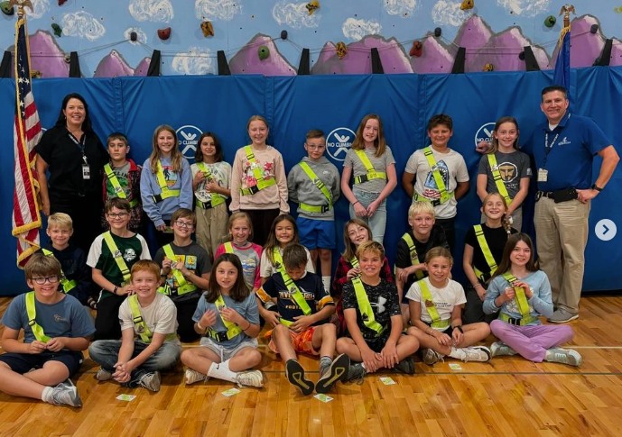 students with a US flag at the safety patrol ceremony
