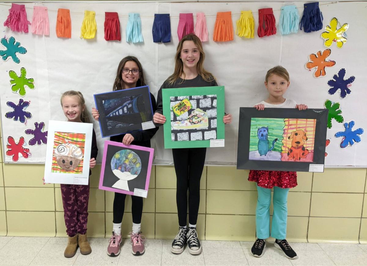 4 students holding their artwork