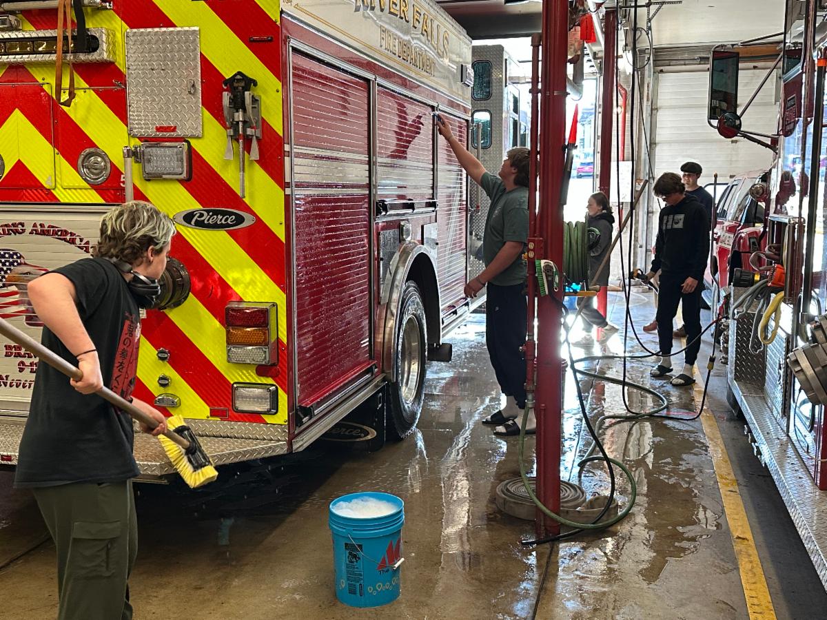 students washing a fire truck