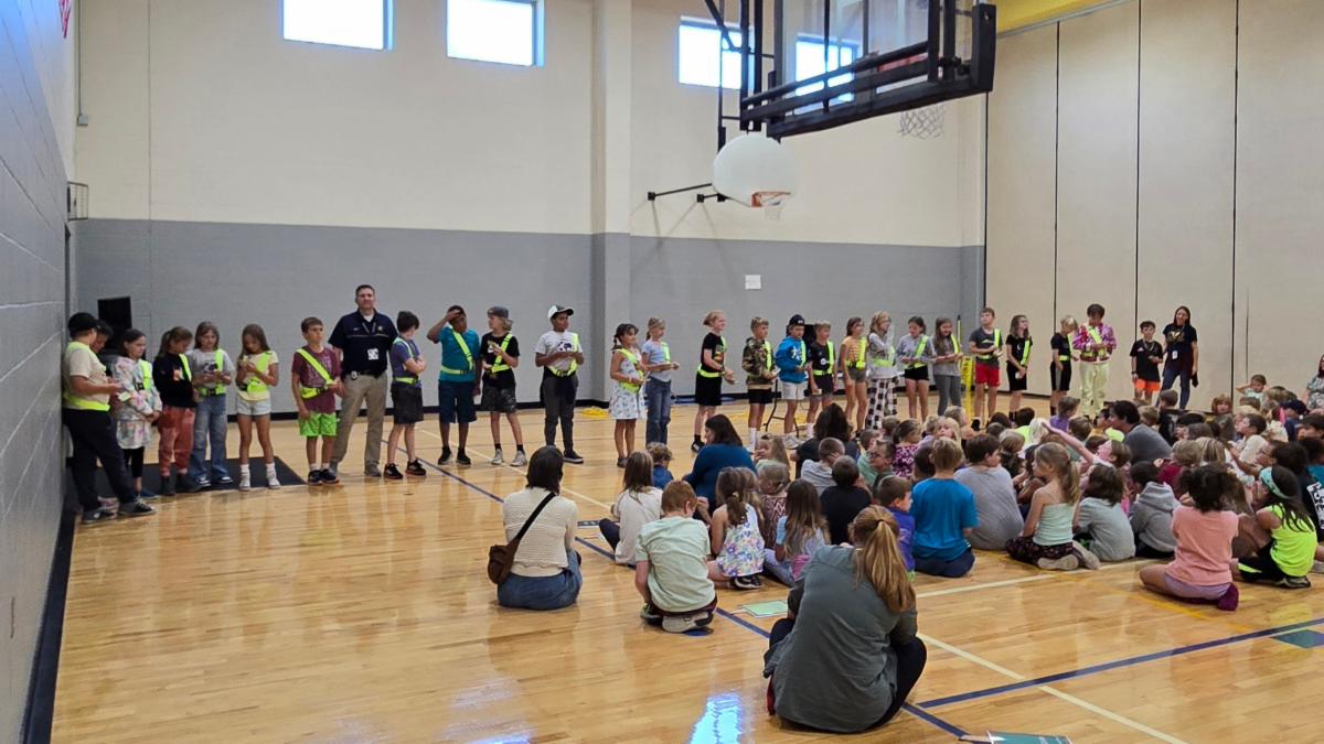 students in a gym at the safety patrol ceremony