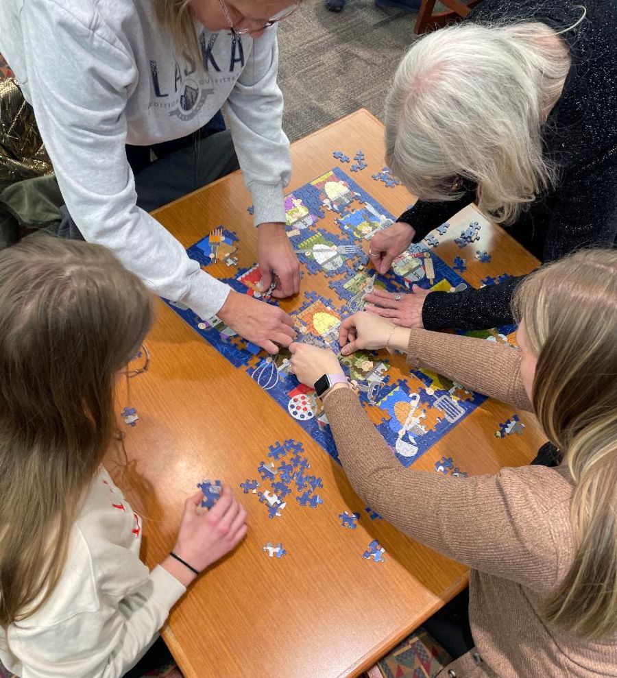 adults putting a puzzle together
