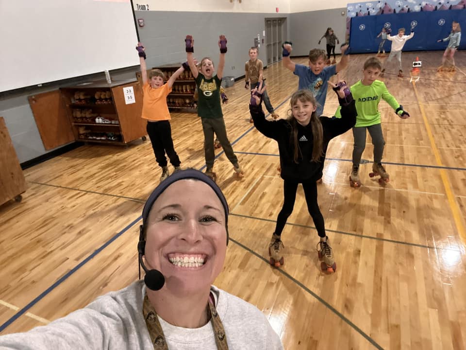 smiling woman and students on skates