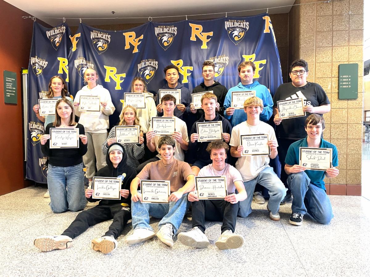 16 students of the term pose for a photo holding their certificates
