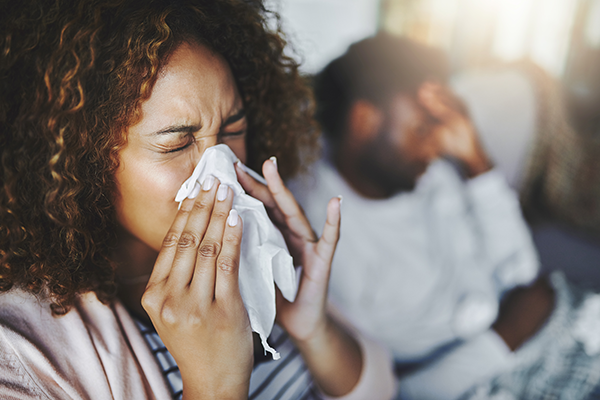 Sick woman blowing her nose