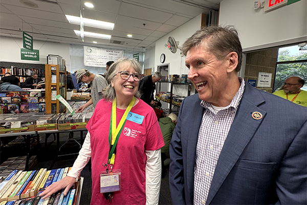 Walter Alcorn talking to Friends of Reston Regional Library volunteer at their book sale