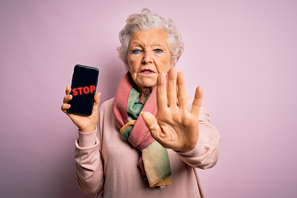 Woman holding a phone that says STOP