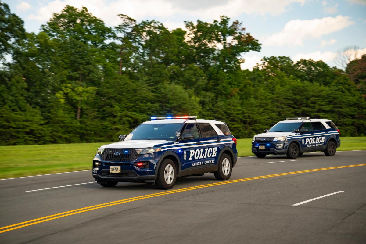 A photo of two Fairfax County police cars on the road