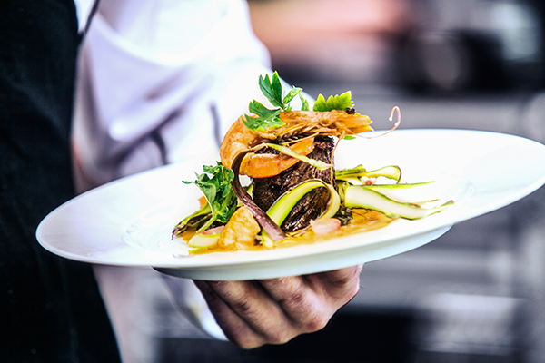 Waiter serving a fine dining meal.