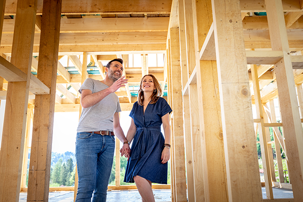 Young couple looking at house under construction