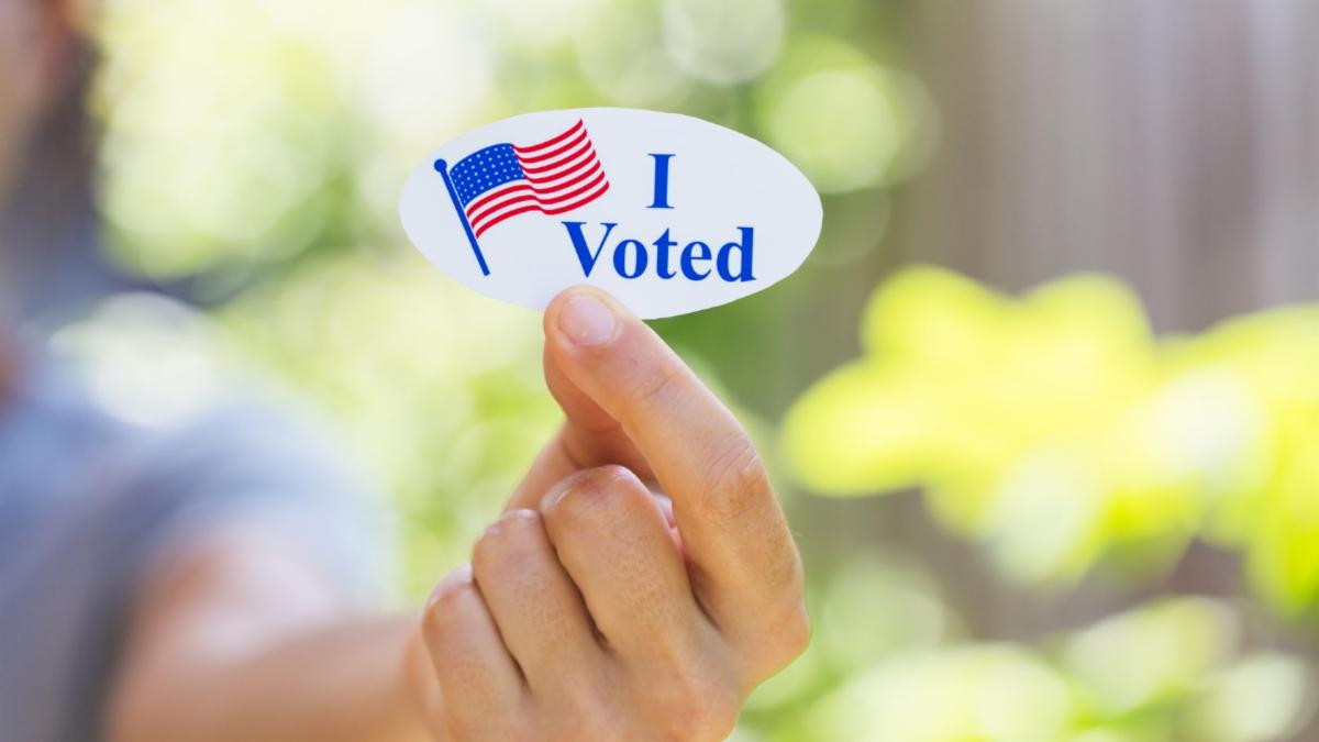 Person holding an "I Voted" sticker