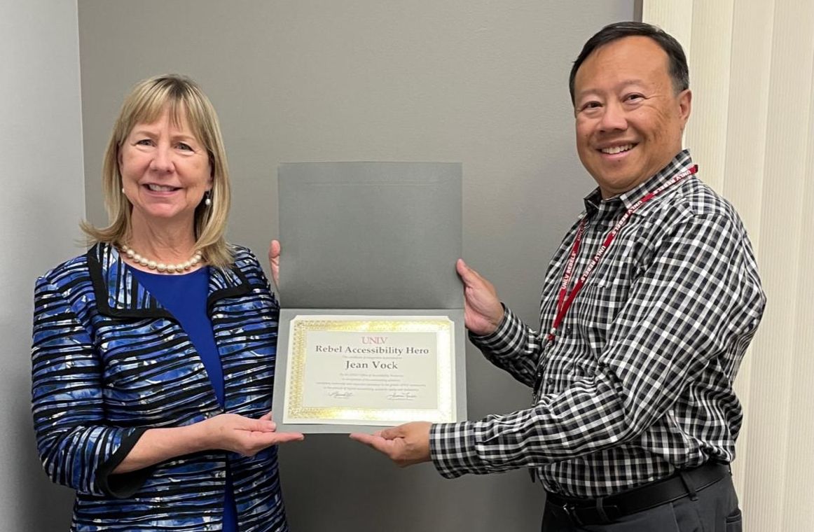 Jean Vock receiving an accessibility award from Rex Scuba