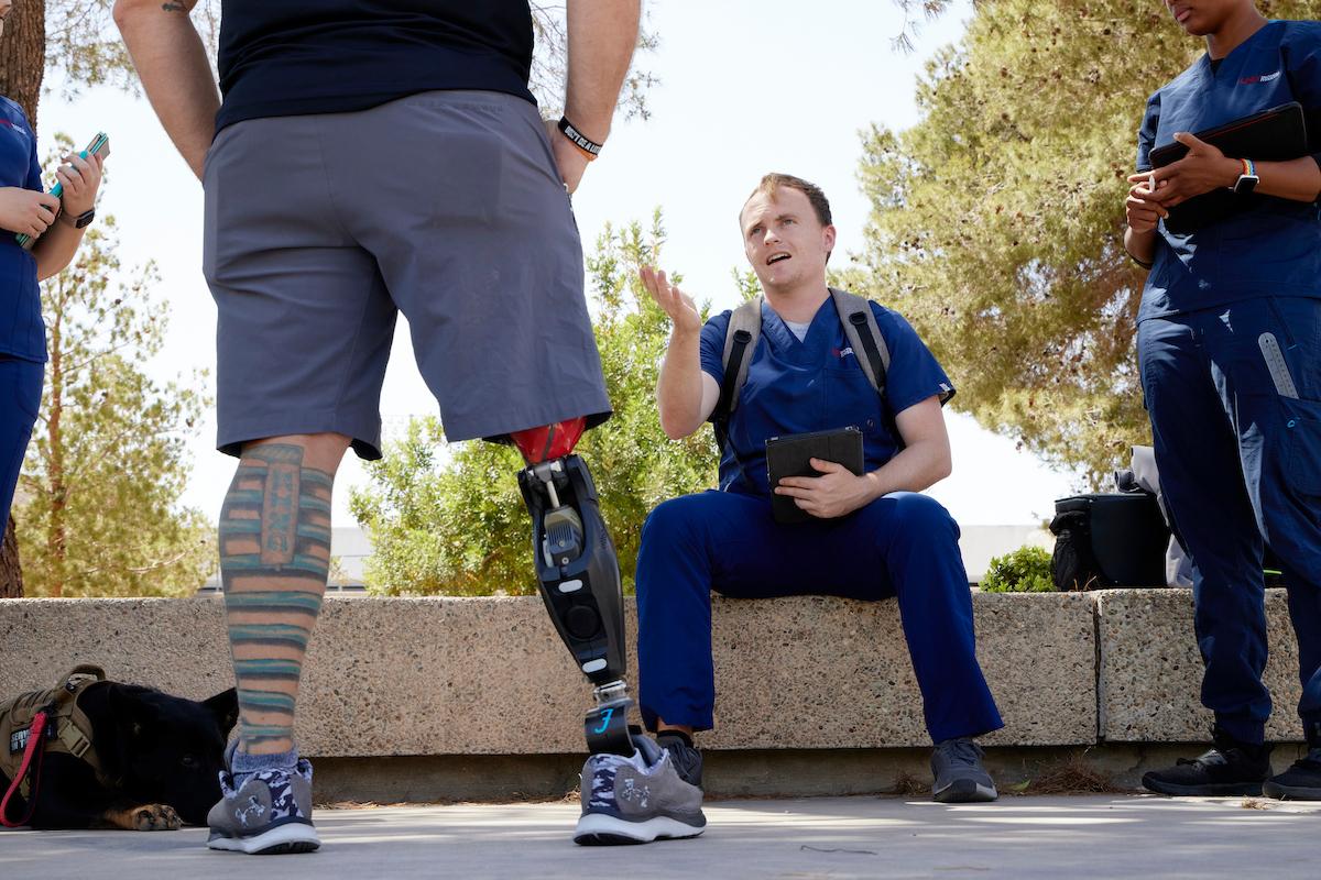 Person with prosthetic leg talking to a friend on UNLV campus