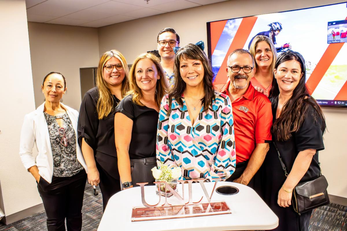 Kim and collegaues pose for a photo in front of her appreciation plaque.