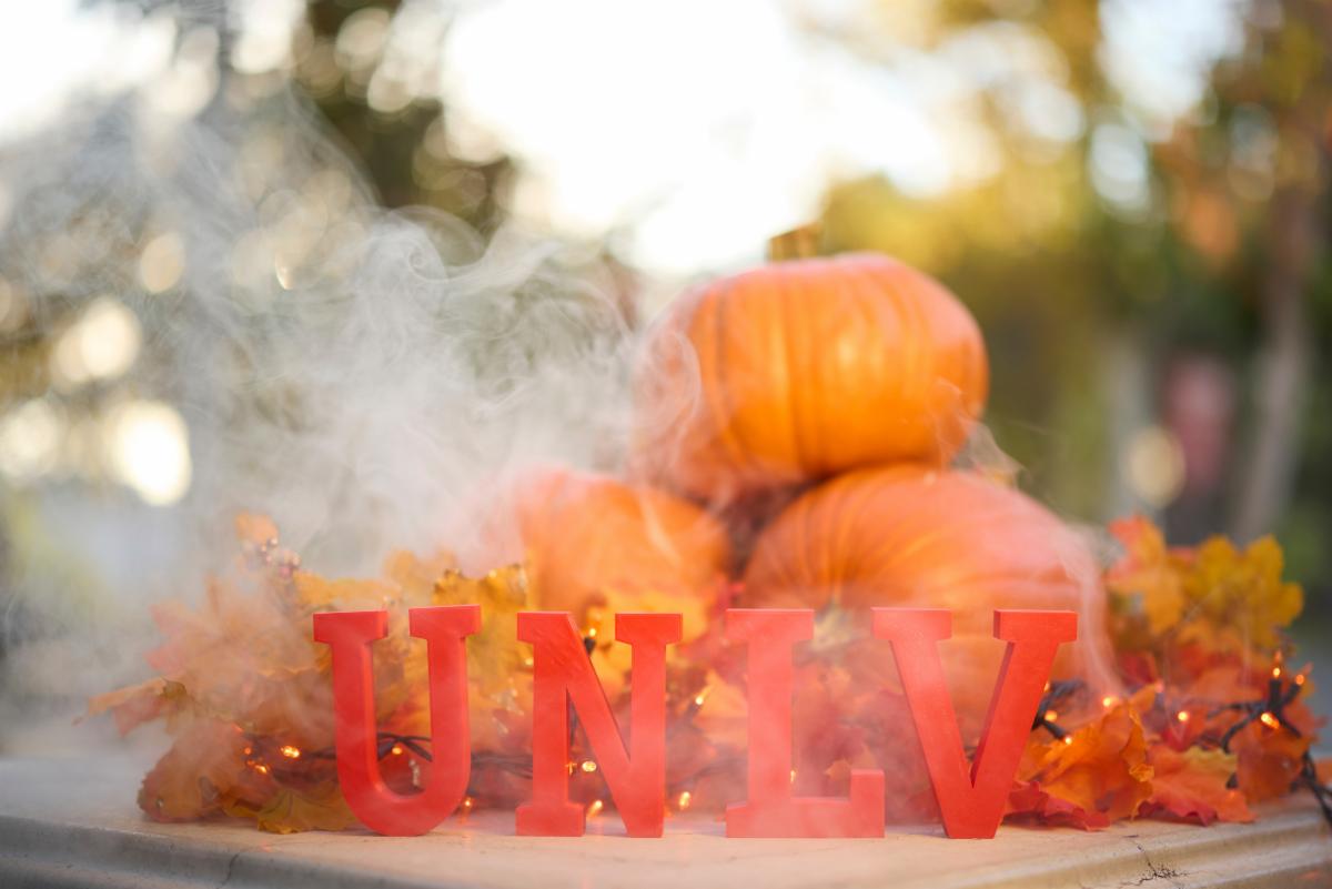 UNLV letters in front of a stack of pumpkins and shrouded in fake smoke