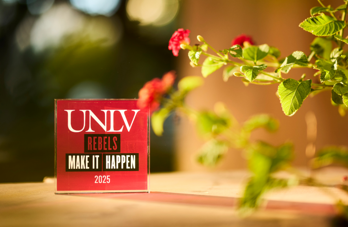 UNLV rebels make it happen sign with rose bush