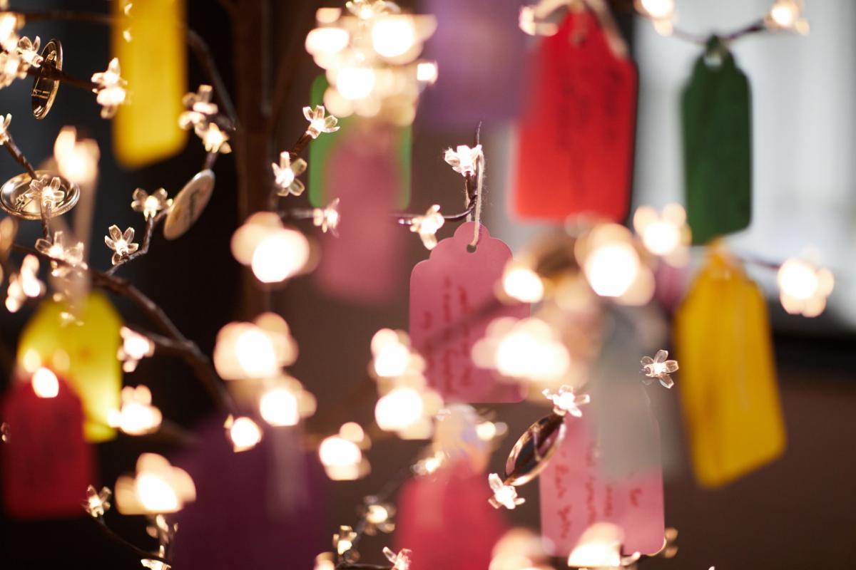Multicolored tags on an angel tree with sparkling lights