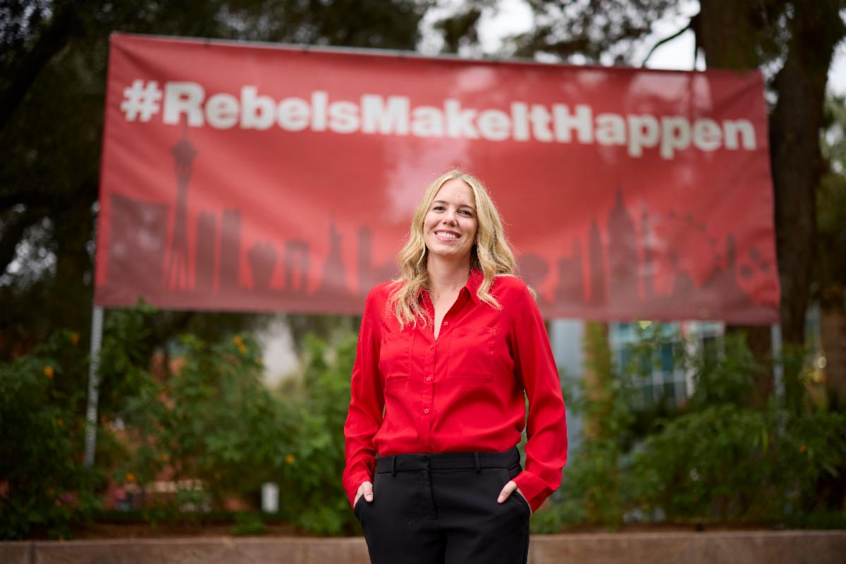 Karlie Passey in front of a Rebels Make It Happen banner