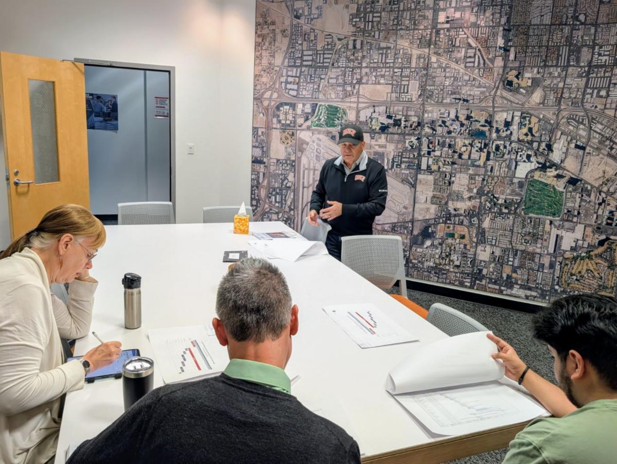 A School of Architecture student reviews the project timeline with two professors for the new parking garage led by project manager Mike Kwiecien.