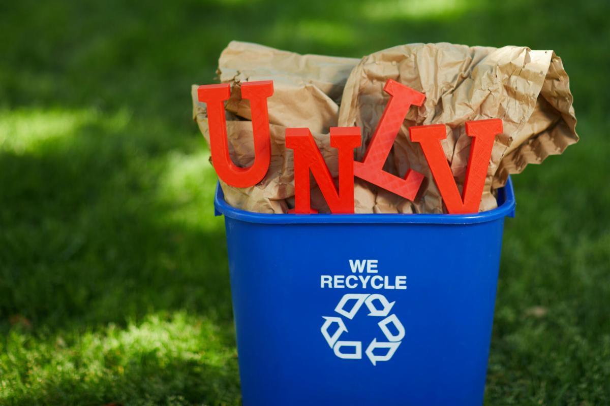 recycling bin filled with paper and red UNLV letters