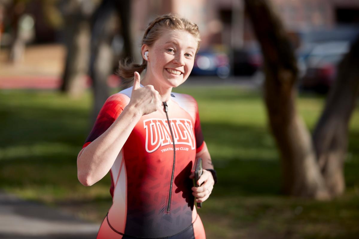 Runner wearing UNLV colors smiling giving thumbs up