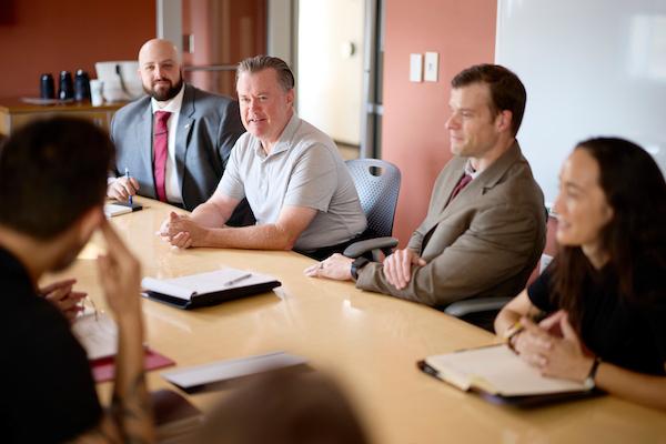 Businesspeople seated around a table in discussion