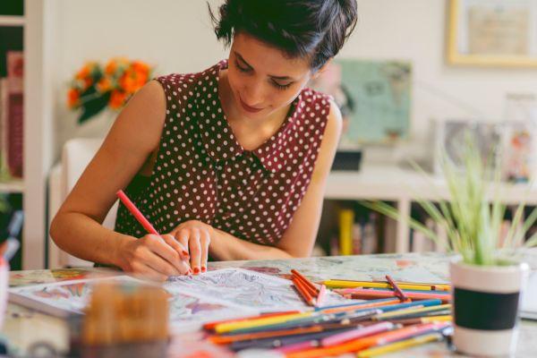 Woman coloring on a page with colored pencils