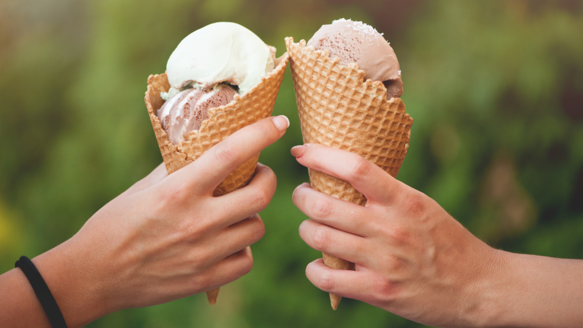 Two hands holding ice cream cones together