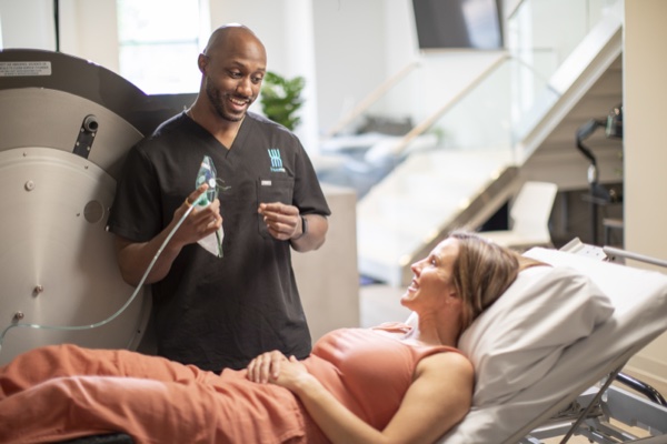 A Huemn specialist with a client at the hyperbaric chamber