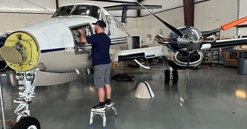 maintenance tech working on plane in hangar