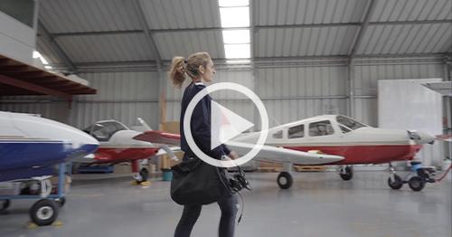 female pilot walking in hangar