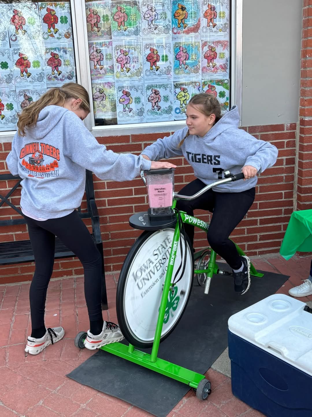 A young girl biking on a smoothie bike.