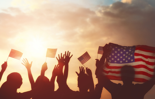 Patriotic holiday. Silhouettes of people holding the Flag of USA. America celebrate 4th of July.