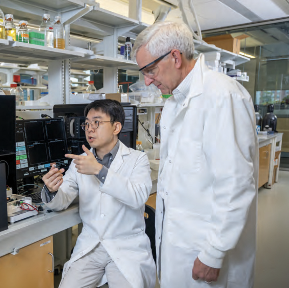 two men in white coats in lab
