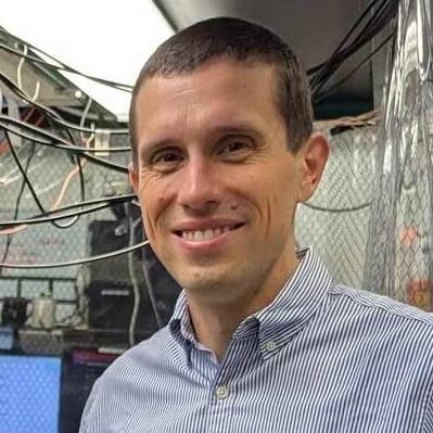 Norbert Linke with computer equipment in the background.