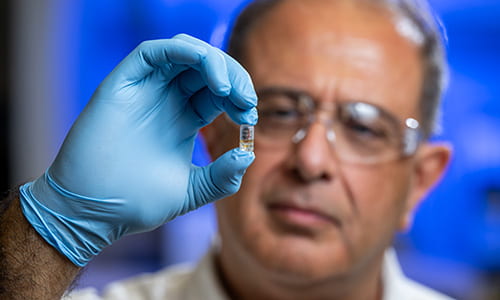 scientist holds out capsule