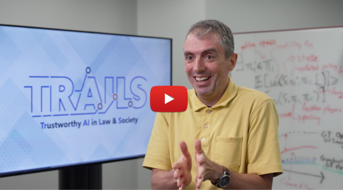 Jordan Boyd-Graber presenting with TRAILS logo and youtube play button