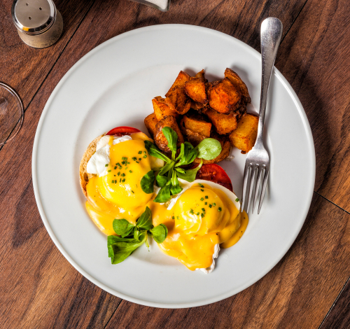 Eggs Benedict is a traditional American breakfast or brunch dish with bacon_ ham_ a poached egg_ and hollandaise sauce.